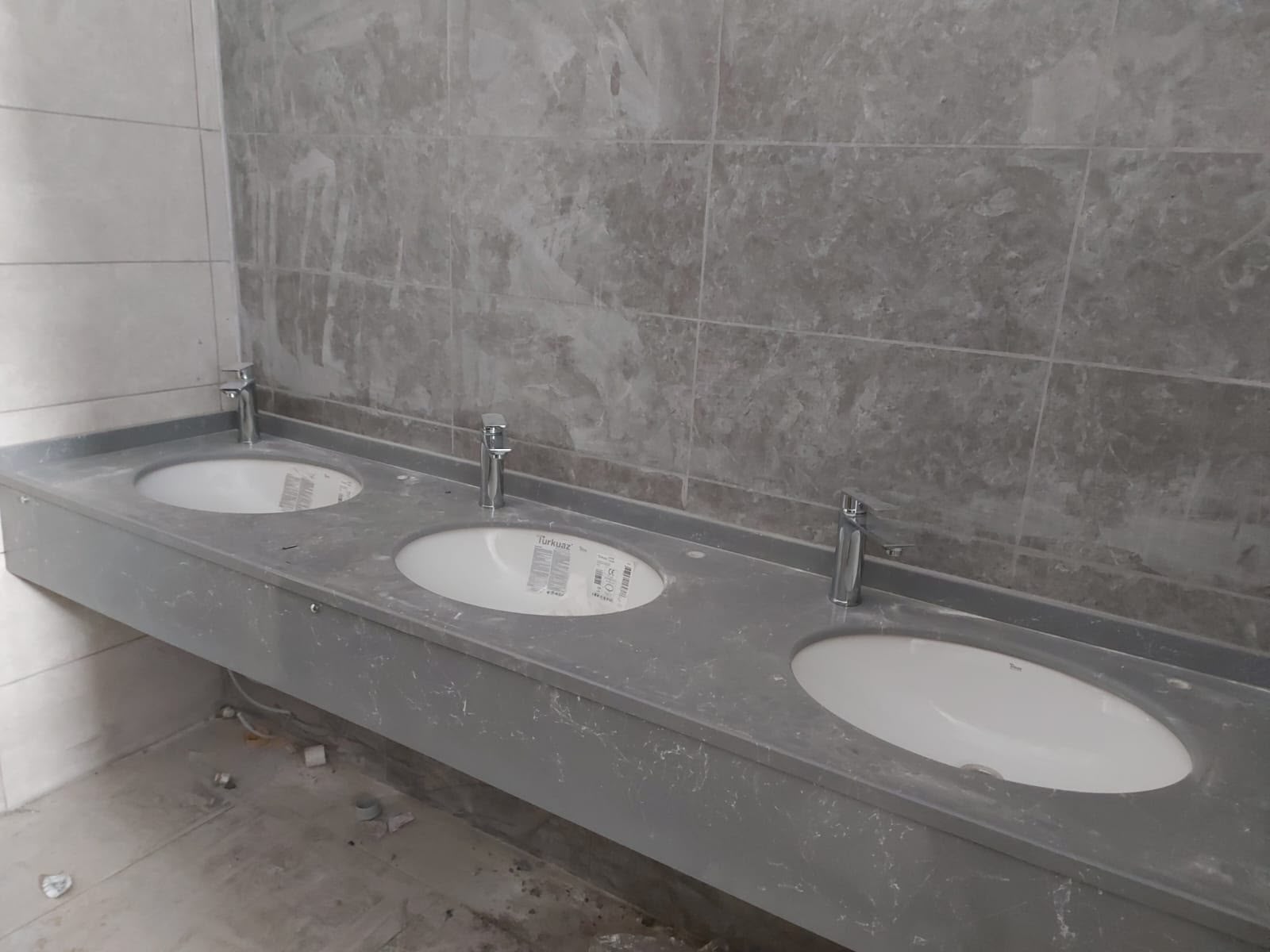Gri damarlı mermerit banyo tezgahı ve üç yuvarlak lavabo